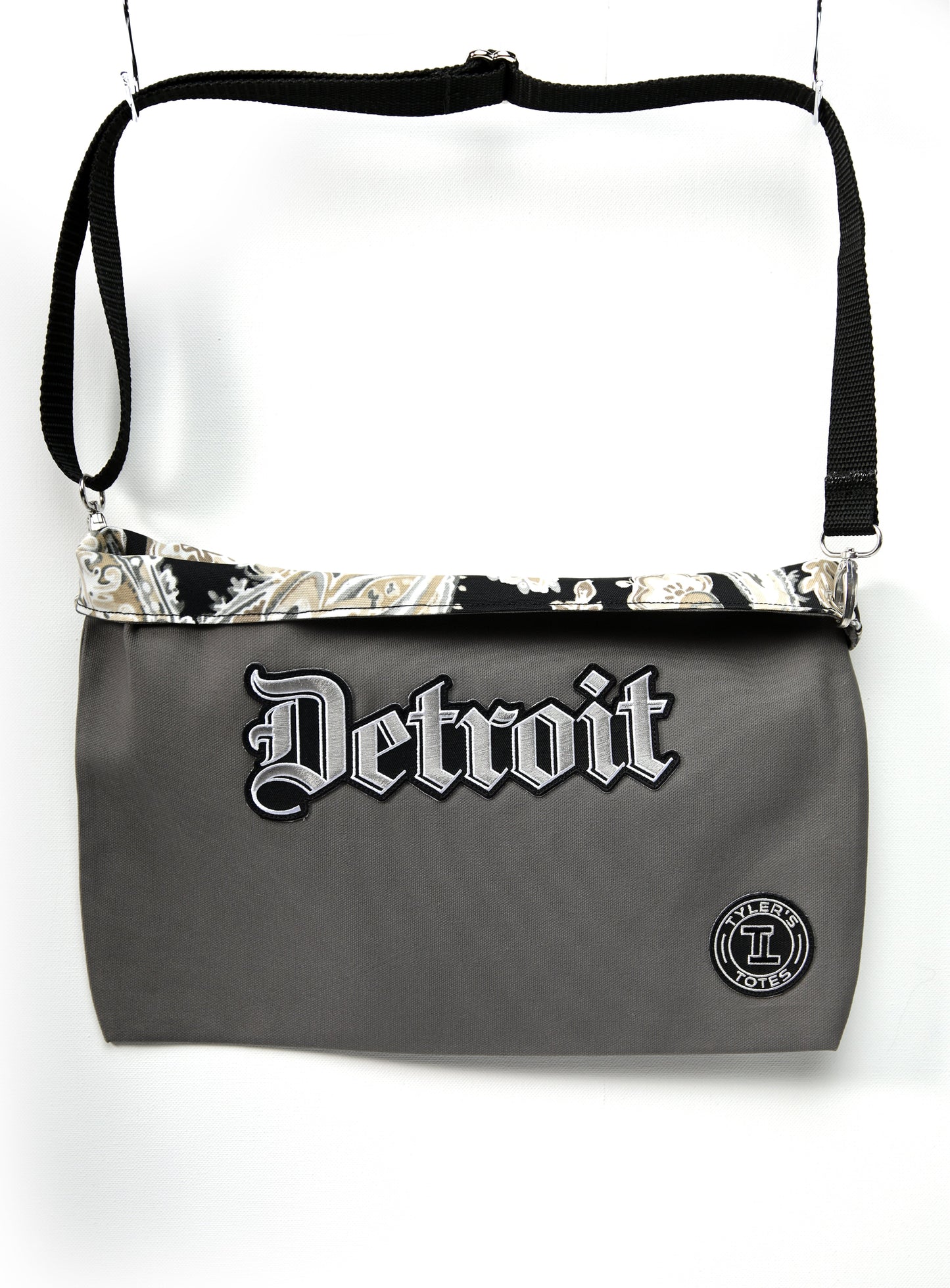 Grey square tote bag with "Detroit" Old English text and paisley print interior.